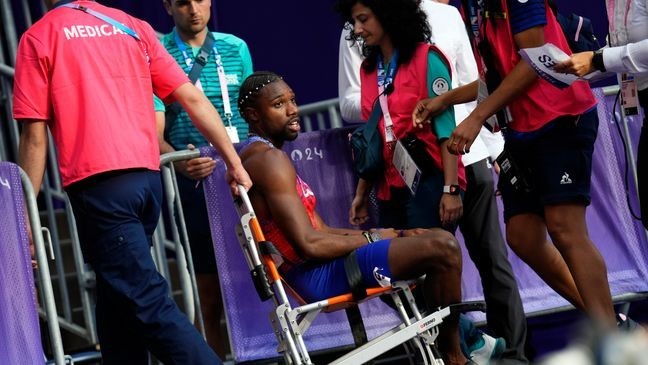 Noah Lyles, of the United States, is taken from the track following the men's 200-meters final at the 2024 Summer Olympics, Thursday, Aug. 8, 2024, in Saint-Denis, France. (AP Photo/Petr David Josek)