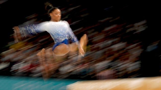 In this photo made with a slow exposure, Simone Biles, of the United States, warms up during the women's artistic gymnastics individual balance beam finals at Bercy Arena at the 2024 Summer Olympics, Monday, Aug. 5, 2024, in Paris, France. (AP Photo/Abbie Parr)