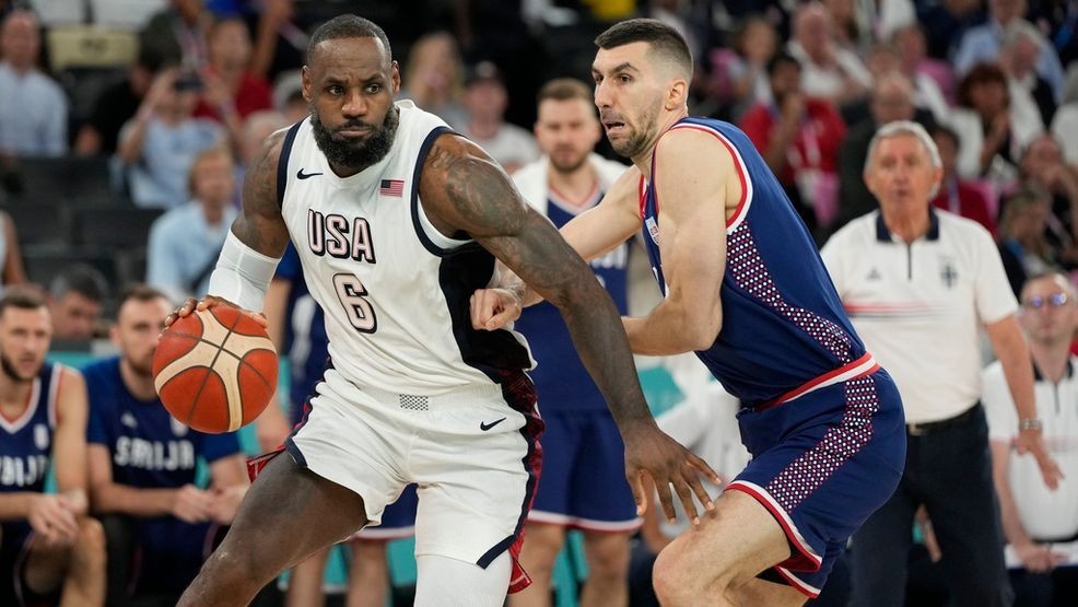 United States' LeBron James (6) drives past Ognjen Dobric (13), of Serbia during a men's semifinals basketball game at Bercy Arena at the 2024 Summer Olympics, Thursday, Aug. 8, 2024, in Paris, France. (AP Photo/Michael Conroy)